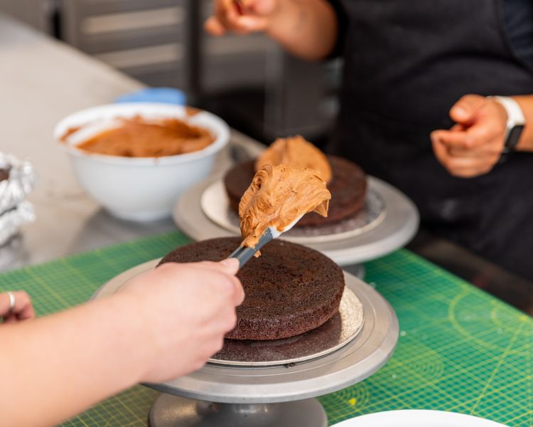 applying icing to cake at cake decorating class in battersea