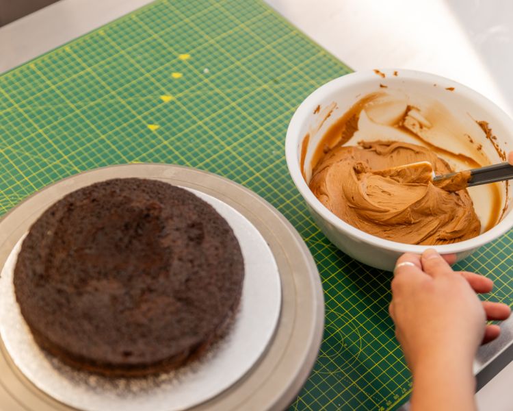 prepping icing to ice a red velvet cake at cake decorating class in battersea