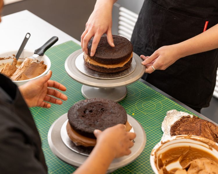 Putting cake together to decorate at cake decorating class
