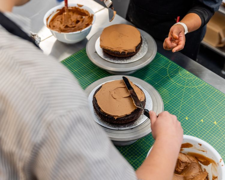 Spreading icing on cake at cake decorating class