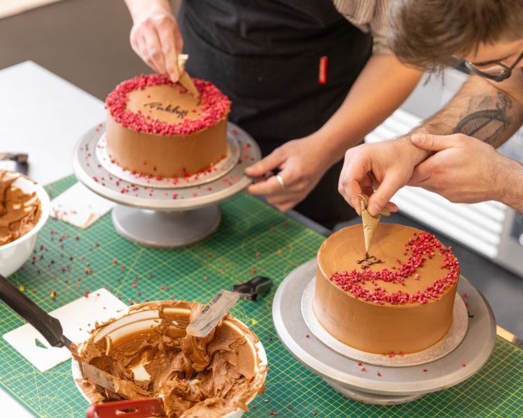 Writing with icing on cake at cake decorating class