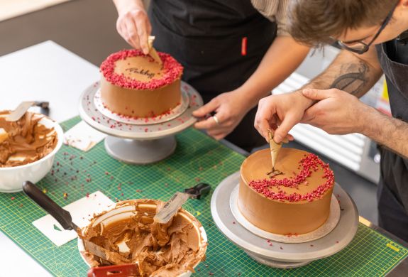Writing with icing on cake at cake decorating class