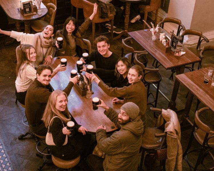 Group with pints of guiness on london pub tour