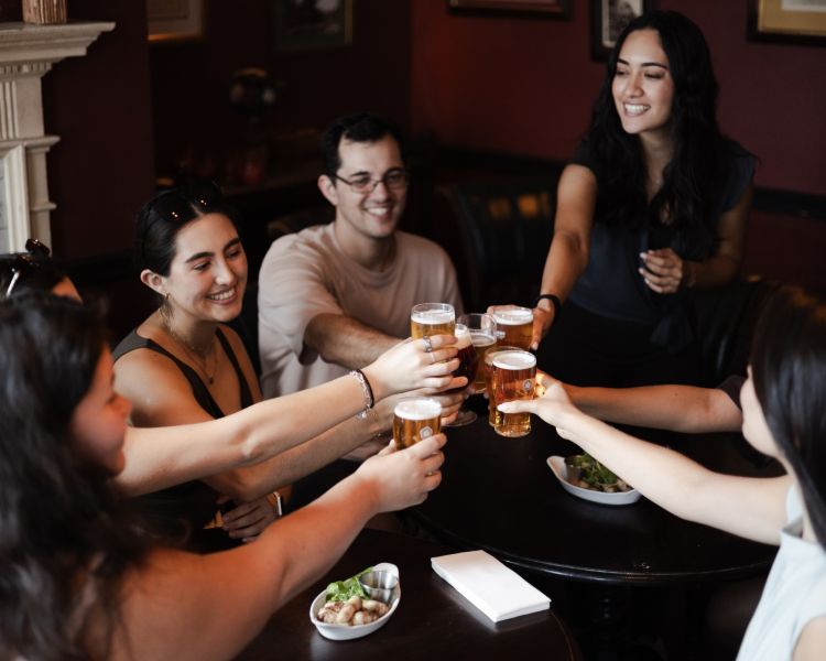 Group with beers and snacks in pub on london pub and food tour