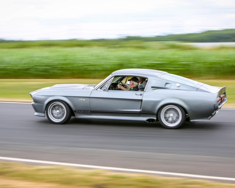 a vintage sports car driving on a race track as part of a driving experience day