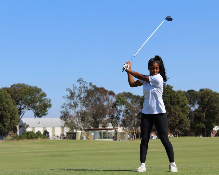 young girl playing golf on golf course