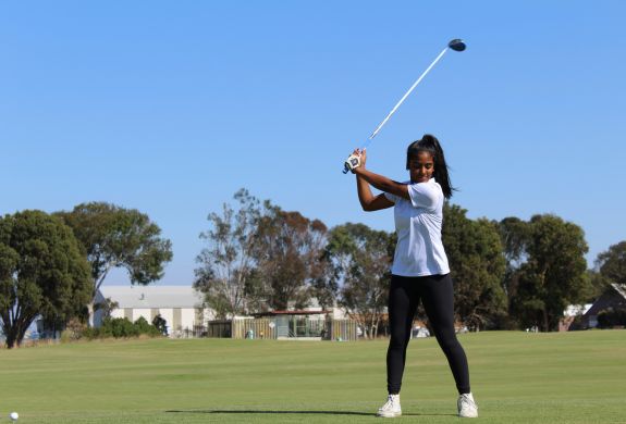 young girl playing golf on golf course