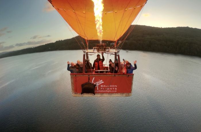 a hot air balloon flying over a lake in lancaster