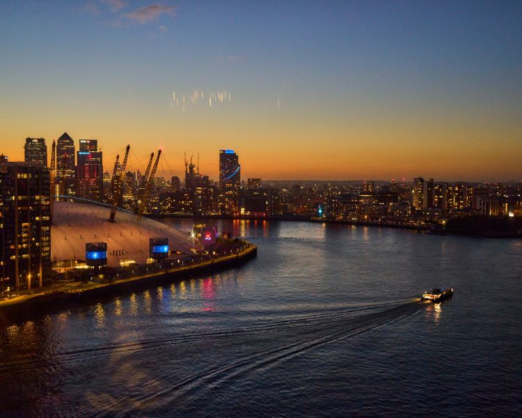 Uber boat passes o2 at dusk