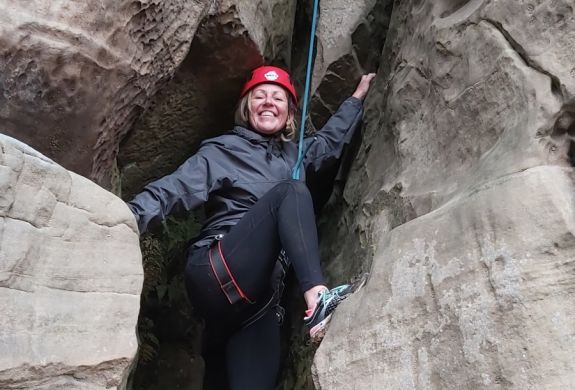 woman standing between rocks on rock climbing experience in sussex and kent