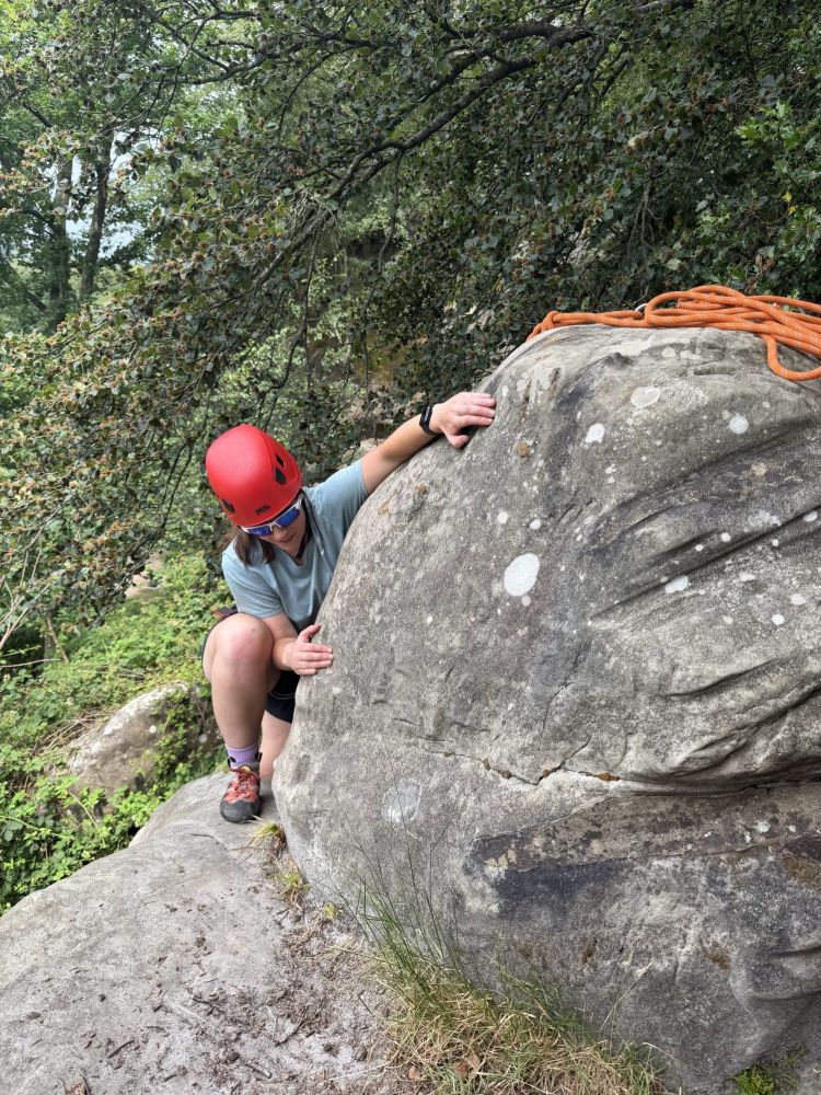 woman climbing around boulder on rock climbing experience in sussex and kent