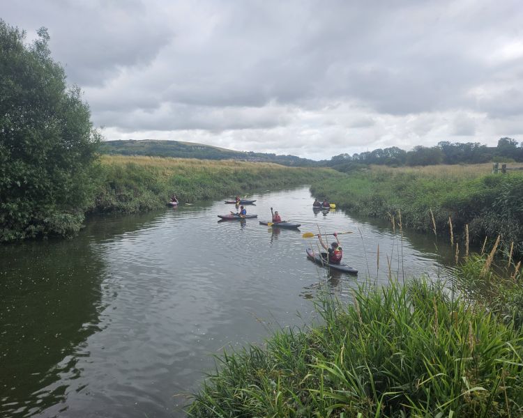 aerial shot of group kayaking down a sussex river