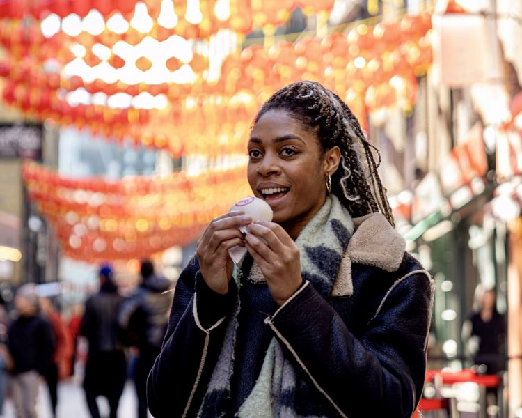 woman eating on food tour through london's chinatown and soho
