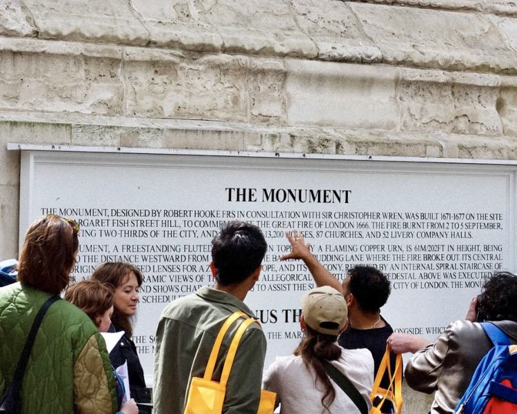 group looking at monument on british empire walking tour in london