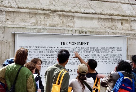 group looking at monument on british empire walking tour in london