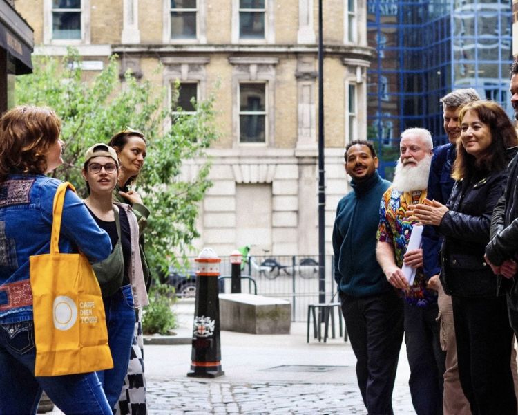 group on london street listening to guide on british empire walking tour in london