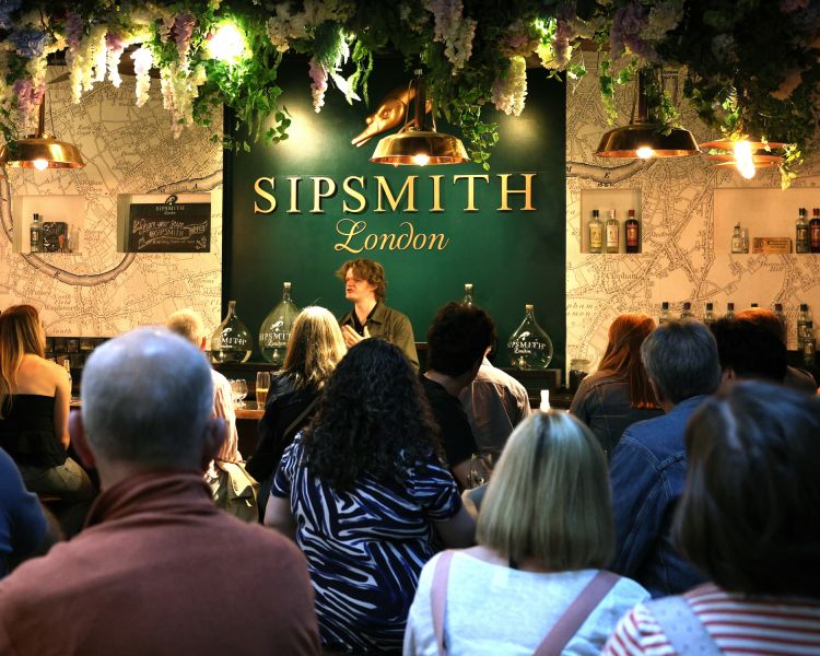 people listening to guide at a sipsmith london gin distillery tour and tasting