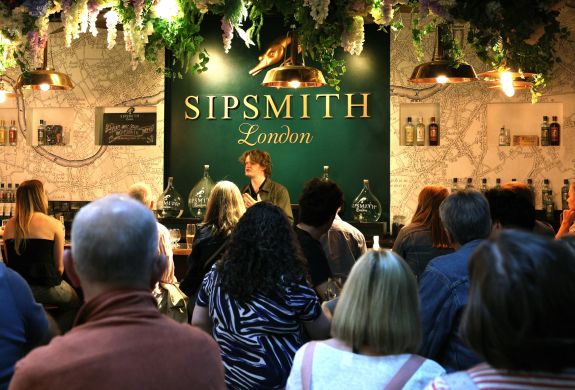 people listening to guide at a sipsmith london gin distillery tour and tasting