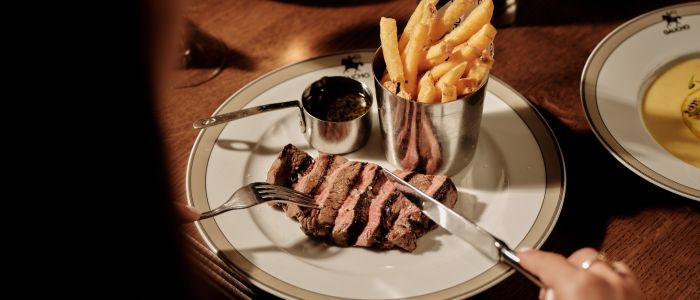 Woman eating the steak dinner from the gaucho pre theatre menu
