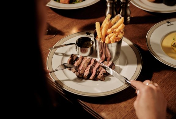 Woman eating the steak dinner from the gaucho pre theatre menu