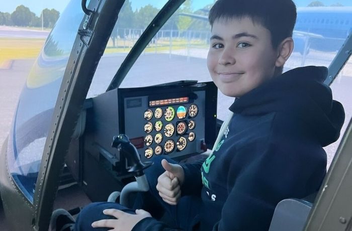 young boy in the cockpit of a jet ranger helicopter flight simulator