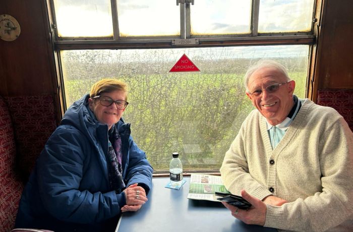 couple sitting in a booth in front of a window on a steam train experience day