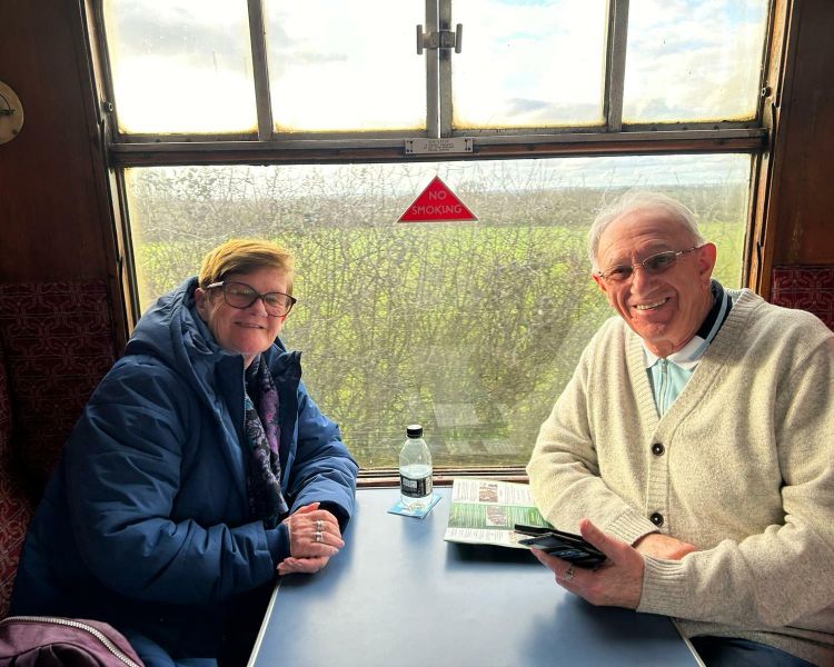 couple sitting in a booth in front of a window on a steam train experience day