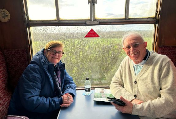 couple sitting in a booth in front of a window on a steam train experience day