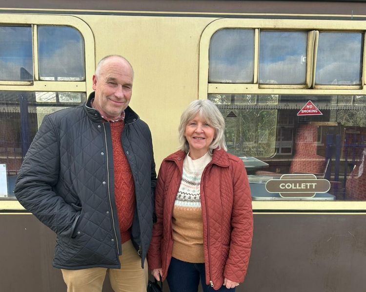 couple standing alongside a train carriage on a steam train experience day