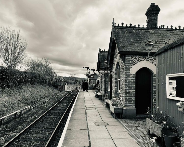 black and white photo of a station platform seen on a steam train experience day