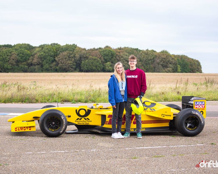 young girl and boy standing next to f1 jordan car on a f1 car photoshoot and passenger lap experience