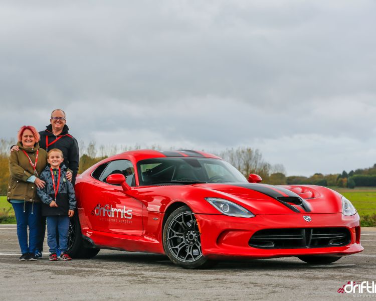 couple and child standing next to sports car on a car photoshoot and passenger lap experience