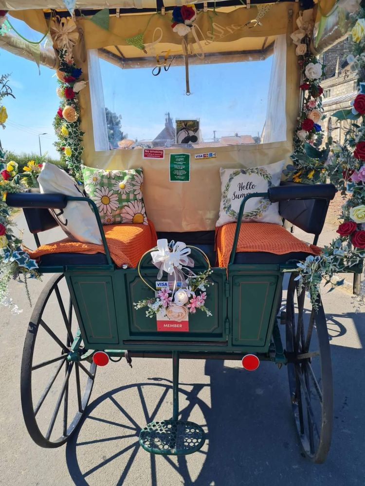 a carriage with cushions and decorated with flowers used for a horse carriage ride experience