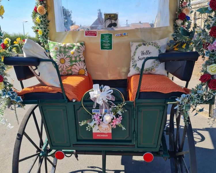 a carriage with cushions and decorated with flowers used for a horse carriage ride experience