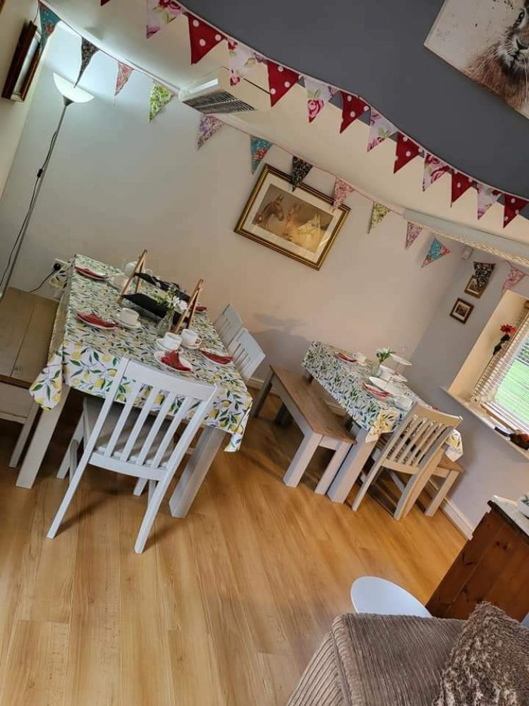 the inside of the tea room at little skipworth carriage rides showing tables, chairs and bunting