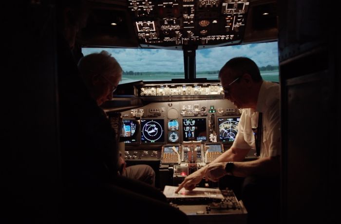 person being shown notes by a copilot in the cockpit of a plane flight simulator at deeside flight simulators