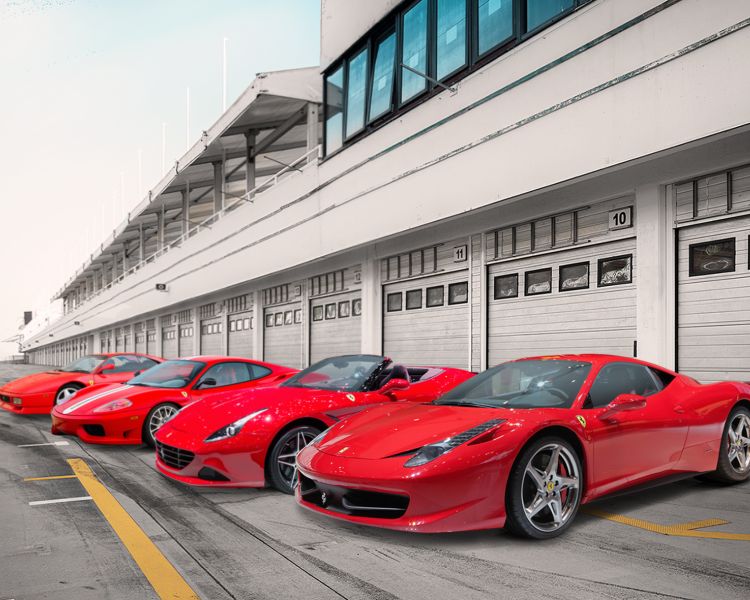 4 red ferrari's lined up on a pit lane as part of a ferrari supercar driving experience