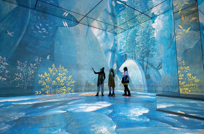 three visitors at the frameless immersive art exhibition in london
