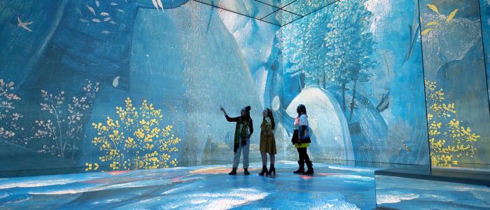 three visitors at the frameless immersive art exhibition in london