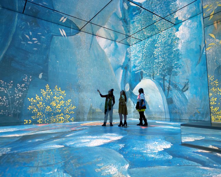 three visitors at the frameless immersive art exhibition in london