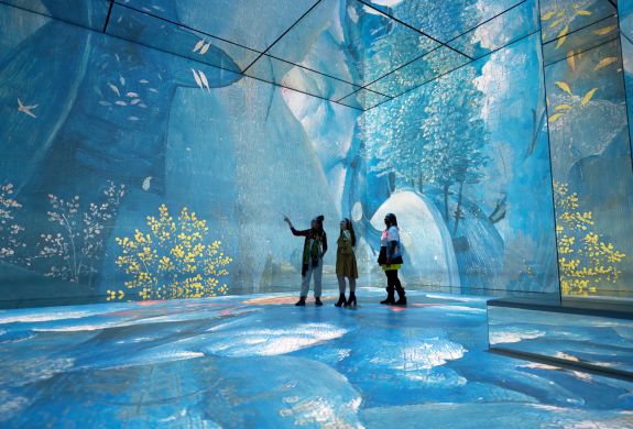 three visitors at the frameless immersive art exhibition in london