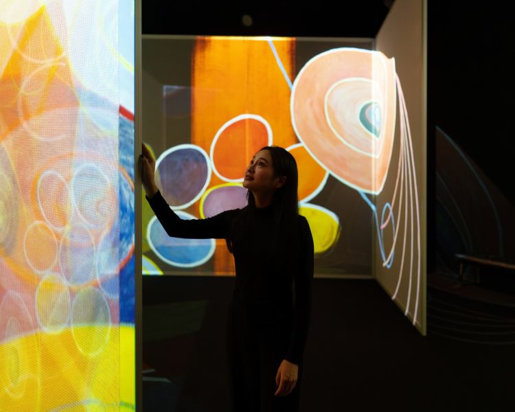 woman visiting the art of abstraction exhibit at the frameless immersive art exhibition in london