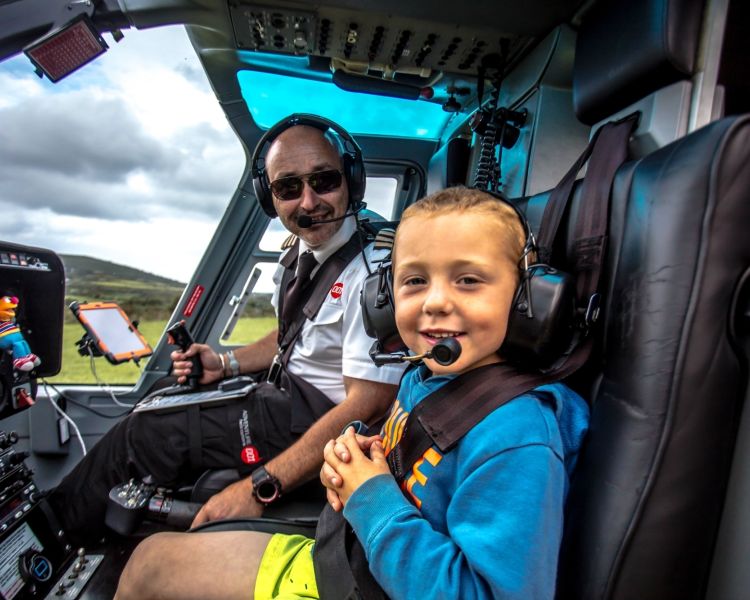 child sitting in the co-pilot seat next to the pilot ready for a helicopter ride experience with adventure 001