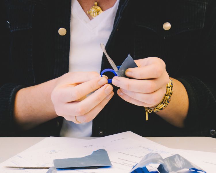 person working on shaping a wax ring template during a gemstone jewellery making workshop with stööki