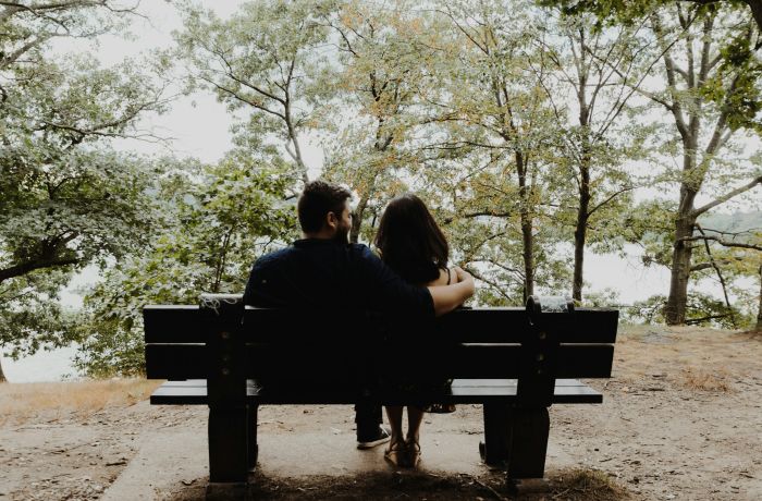 couple sitting on a bench overlooking trees