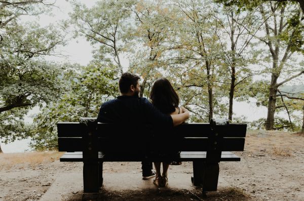 couple sitting on a bench overlooking trees
