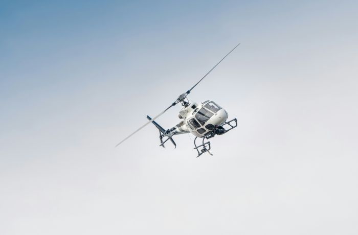 white helicopter at an angle in the sky