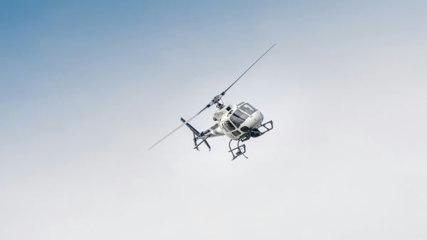 white helicopter at an angle in the sky