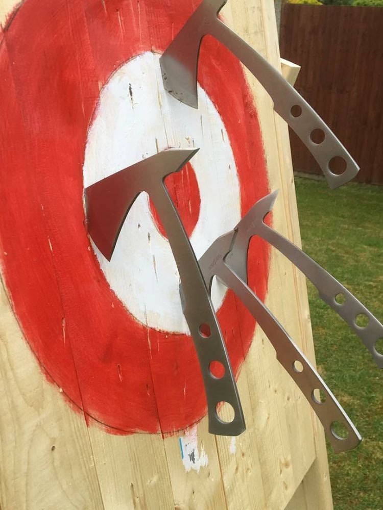 a wooden target with axes stuck in it on an axe throwing experience