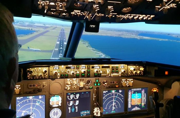the cockpit of a boeing7371 flight simulator and the view of the runway